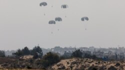 Humanitarian aid falls through the sky toward the Gaza Strip after being dropped from an aircraft, amid the ongoing conflict between Israel and the Palestinian Islamist group Hamas, as seen from Israel, March 28, 2024. 