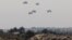 Humanitarian aid falls through the sky toward the Gaza Strip after being dropped from an aircraft, amid the ongoing conflict between Israel and the Palestinian Islamist group Hamas, as seen from Israel, March 28, 2024. 
