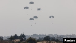 2024年3月28日，在以色列与哈马斯之间持续不断的冲突中，人道主义援助物资从飞机空投下来后落向加沙地带。（路透社照片）