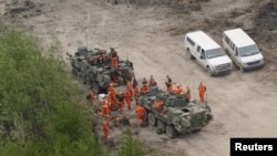 FILE - Canadian troops wrap up for the day after extinguishing hot spots near La Ronge, Saskatchewan, July 12, 2015, in a photo released by the Canadian Forces. Most recently, the Canadian military has been called in to help fight wildfires in the country's Northwest Territories.