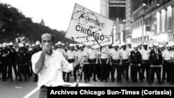 Un manifestante lucha contra los gases lacrimógenos mientras camina frente a una barricada policial en el Hotel Conrad Hilton durante la Convención Nacional Demócrata de 1968 en Chicago.