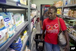 Jeanne Musaga shops at a social group store, Aug. 6, 2024, during the 2024 Summer Olympics, in Epinay-sur-Seine, France.