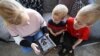 ILUSTRASI - Charlie dan Jack Walker mendengarkan cerita yang diposting oleh staf Little Stars Childcare di aplikasi taman kanak-kanak dan Facebook mereka di Newcastle-under-Lyme , Inggris, 24 Maret 2020. (REUTERS/Carl Recine)