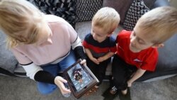 ILUSTRASI - Charlie dan Jack Walker mendengarkan cerita yang diposting oleh staf Little Stars Childcare di aplikasi taman kanak-kanak dan Facebook mereka di Newcastle-under-Lyme , Inggris, 24 Maret 2020. (REUTERS/Carl Recine)