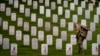 FILE - A member of The Old Guard, places flags in front of each headstone for "Flags-In" at Arlington National Cemetery in Arlington, May 25, 2023, to honor the Nation's fallen military heroes ahead of Memorial Day. (AP Photo/Andrew Harnik, file)