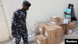 A police official walks past boxes with voting materials for distribution, at the Central Bank of Nigeria, ahead of Nigeria's Presidential elections, in Yola, Nigeria, Feb. 23, 2023. 