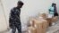 A police official walks past boxes with voting materials for distribution, at the Central Bank of Nigeria, ahead of Nigeria's Presidential elections, in Yola, Nigeria, Feb. 23, 2023. 