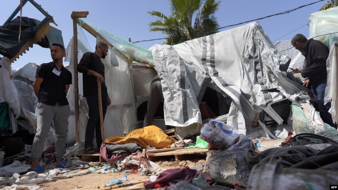 Palestinians check the damage at a makeshift camp for displaced people in front of Al-Aqsa Hospital in Deir al Balah, Gaza Strip, after it was hit by Israeli airstrikes on March 31, 2024.