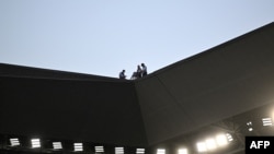 在若弗鲁瓦·吉夏尔体育场举行的一场英式橄榄球比赛期间，安保人员在体育场屋顶上工作。（2023年9月17日）