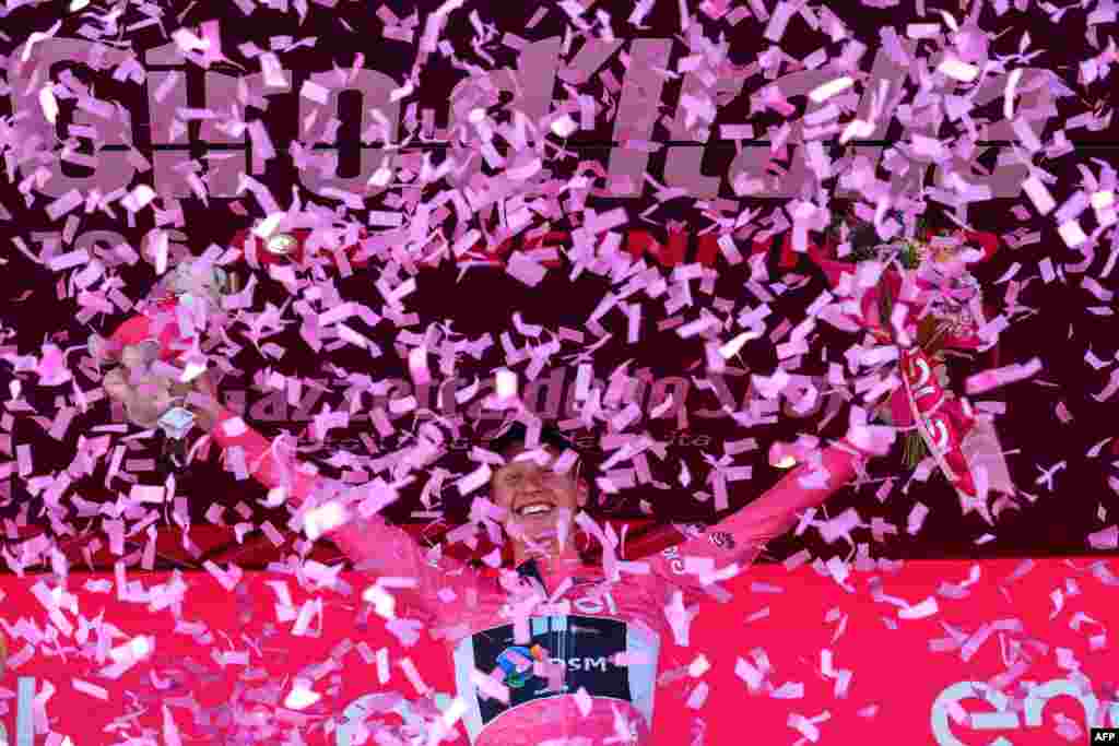 Team DSM's Norwegian rider Andreas Leknessund celebrates his overall leader's pink jersey on the podium after the sixth stage of the Giro d'Italia 2023 cycling race.