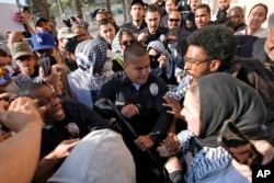 Los Angeles Police Department officers clash with pro-Palestinian demonstrators at the Shrine Auditorium where a commencement ceremony for graduates from Pomona College was being held Sunday, May 12, 2024, in Los Angeles. (AP Photo/Ryan Sun)