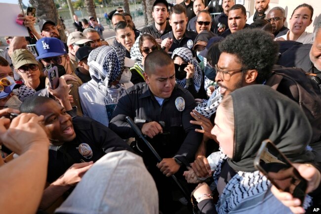 Los Angeles Police Department officers clash with pro-Palestinian demonstrators at the Shrine Auditorium where a commencement ceremony for graduates from Pomona College was being held Sunday, May 12, 2024, in Los Angeles. (AP Photo/Ryan Sun)