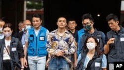 被判無罪的前民主派區議員李予信（左三）在47人案中被判無罪後離開香港西九龍裁判法院。 （2024年5月30日）