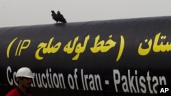 FILE - An Iranian worker walks past the Pakistan-Iran Gas Pipeline Project in Gabd near Pakistani border in Iran, March 11, 2013. 