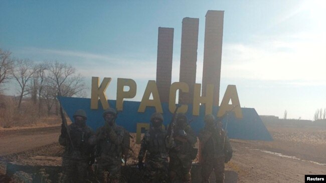Në fotografinë e qarkulluar nga Grupi Wagner duket se pozojnë mercenarët në hyrje të fshatit Krasna Hora (12 shkurt 2023)