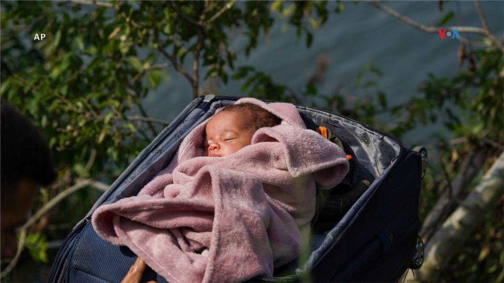  Migrantes cruzan el Río Bravo hacia Estados Unidos con un bebé en una maleta, visto desde Matamoros, México, el 10 de mayo de 2023. &nbsp; 