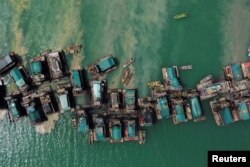 FILE - An aerial view shows wooden pontoons equipped to dredge the seabed for deposits of tin ore off the coast of Toboali, on the southern shores of the island of Bangka, Indonesia, May 1, 2021.