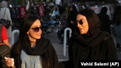 Women talk as they walk around Tajrish commercial district without wearing their mandatory Islamic headscarf in northern Tehran, Iran, Saturday, April 29, 2023. AP Photo/Vahid Salemi)