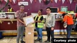 Anggota PPLN Papua Nugini Adiputra Nugraha (kanan) ketika menyerahkan surat suara pos kepada Air Niugini Cargo untuk dikirim kepada WNI di wilayah Papua Nugini (foto PPLN Papua Nugini)