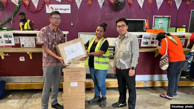 Anggota PPLN Papua Nugini Adiputra Nugraha (kanan) ketika menyerahkan surat suara pos kepada Air Niugini Cargo untuk dikirim kepada WNI di wilayah Papua Nugini (foto PPLN Papua Nugini)
