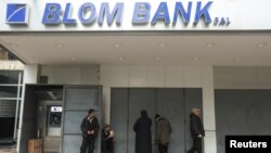 People stand outside a closed branch of Blom Bank in Sidon, Lebanon, Feb. 7, 2023. 