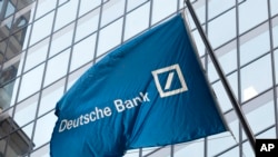 FILE - A Deutsche Bank flag flies outside the German bank's New York offices on Wall Street, Oct. 7, 2016.