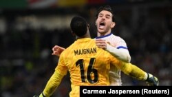 Mike Maignan dan Theo Hernandez dari Tim Nasional Prancis merayakan setelah memenangkan kemenangan mereka dalam adu penalti Euro 2024 di Jerman, 5 Juli 2024. (Foto: REUTERS/Carmen Jaspersen)