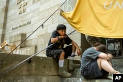 Michael Pacio Ximio, 19, sits on the steps of Dorrance Hamilton Hall at the University of the Arts, Friday, June 14, 2024, in Philadelphia. Students at the university learned recently that their school would be shutting down within days. (AP Photo/Joe Lamberti)