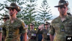 FILE - Soldiers salute during an Anzac Day dawn service at Coogee Beach in Sydney, Australia, April 25, 2024. Australia will allow non-citizens to join its armed forces, the government says. 