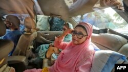 Pemimpin oposisi Bangladesh Khaleda Zia (kanan) duduk di dalam mobil setelah dibebaskan, karena alasan medis, dari penjara tempat dia menghabiskan lebih dari dua tahun karena korupsi, di Dhaka pada 25 Maret 2020. (Rubel Rashid / AFP)