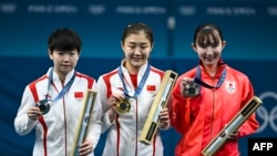 (Dari kiri) Peraih medali perak Sun Yingsha dari China, peraih medali emas Chen Meng dari China, dan peraih medali perunggu Hina Hayata dari Jepang di podium setelah perebutan medali emas tunggal tenis meja putri di South Paris Arena, Paris, 3 Agustus 2024. (WANG Zhao/AFP)