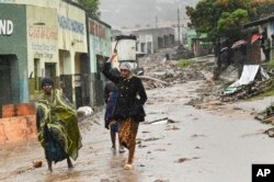 Women walk to a nearby displacement center in Blantyre, Malawi, March 14, 2023.