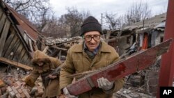 Hennadiy Mazepa and his wife, Natalia Ishkova, collect wood from a house which was destroyed by Russian forces in Chasiv Yar, Ukraine, March 3, 2023.