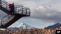 Una mujer camina por unas escaleras desde un paso elevado que cruza la carretera que une las ciudades de El Alto y La Paz, Bolivia, el jueves 4 de marzo de 2021.