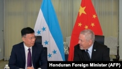 Handout picture released by the Honduran Foreign Ministry showing Honduran Foreign Minister Eduardo Enrique Reina, right, holding a meeting with China's Government Advisor, Yu Bo, and their delegations, in Tegucigalpa on April 11, 2023. 