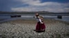 FILE - Maruja Inquilla berjalan di bagian Danau Titicaca yang kering di Coata, Peru, Rabu, 29 November 2023, di tengah gelombang panas. (AP/Martin Mejia)