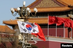 Bendera Korea Selatan dan China berkibar di samping Gerbang Tiananmen selama kunjungan Presiden Korea Selatan Moon Jae-In di Beijing, China, 15 Desember 2017. (Foto: REUTERS/Jason Lee)