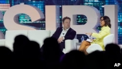 PDG Twitter Elon Musk (mitan) ale ak Linda Yaccarino, direktris pwomosyon ak patenarya pou NBC Universal, nan Miami Beach, Florid, 18 Avril 2023. 