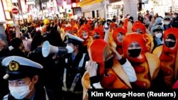 Petugas polisi mencoba mengendalikan massa yang berkumpul untuk merayakan Halloween di jalan kawasan hiburan dan perbelanjaan Shibuya Tokyo di Tokyo, Jepang, 31 Oktober 2022. (Foto: REUTERS/Kim Kyung-Hoon)