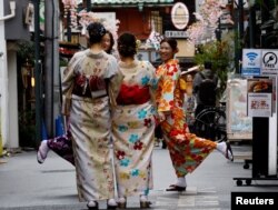 Turis mengenakan Kimono, pada hari pertama pelonggaran pedoman resmi pemerintah Jepang tentang penggunaan masker untuk mencegah penularan virus COVID-19, di distrik Asakusa di Tokyo, Jepang, 13 Maret 2023. (REUTERS/Kim Kyung-Hoon)