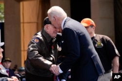 President Joe Biden speaks with World War II veteran Bob Pedigo after French President Emmanuel Macron honored Pedigo with the Legion of Honor medal, during a ceremony to mark the 80th anniversary of D-Day, June 6, 2024, in Normandy.
