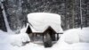 Seorang calon penumpang duduk di halte bus yang tertutup salju di Olympic Valley, California, 24 Februari 2023. California dan sebagian wilayah Barat diguyur hujan dan salju lebat dari badai musim dingin. (Foto: John Locher/AP Photo)
