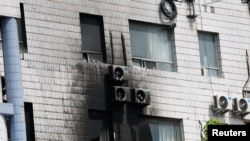 Bagian dari jendela dan dinding luar dari gedung Rumah Sakit Changfeng di Beijing, China, pada 19 April 2023, terlihat mengalami kerusakan menyusul insiden kebakaran yang terjadi pada gedung rumah sakit tersebut. (Foto: Reuters/Tingshu Wang)