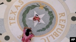 Michaela Herrera takes photos of her eight-month-old daughter, Jayzaiyah, at the Texas Capitol on May 6, 2021. More than 49% of Texans under the age of 18 are Hispanic, according to recent census estimates.