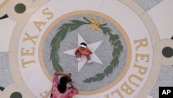 Michaela Herrera toma fotografías de su hija de ocho meses, Jayzaiyah, en el Capitolio de Texas el 6 de mayo de 2021. Más del 49% de los texanos menores de 18 años son hispanos, según estimaciones del censo reciente.