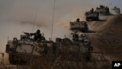 Israeli tanks and APC head towards the Gaza Strip border in southern Israel, Oct.13, 2023.