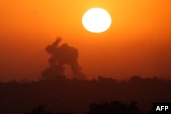 This picture taken from Israel's southern border with the Gaza Strip shows smoke billowing in the Palestinian territory at sunset following Israeli bombardment on June 2, 2024.