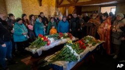 Relatives and family friends attend the funeral of Sofia Shulha, 11, and Kyrylo Pysarev, 17, in Uman, central Ukraine, April 30, 2023. Both were killed during a Russian attack on a residential building early Friday morning.