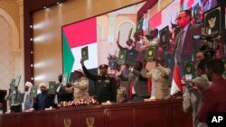 FILE - Sudan's Army chief Gen. Abdel-Fattah Burhan, center, and others hold a document following the signature of an initial deal aimed at ending a deep crisis caused by last year's military coup, in Khartoum, Dec. 5, 2022. 