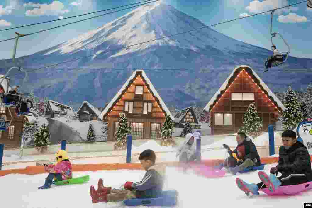 People ride sleighs on artificial snow at Trans Snow World Bintaro, an indoor snow park with a Japanese theme, in Bintaro, Indonesia.